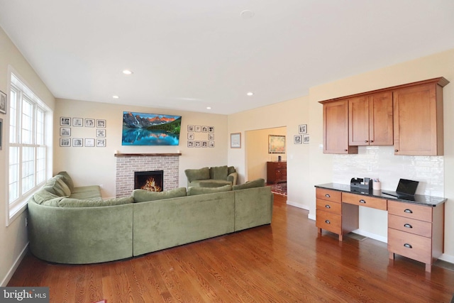 living area with dark wood-style floors, recessed lighting, a fireplace, and baseboards