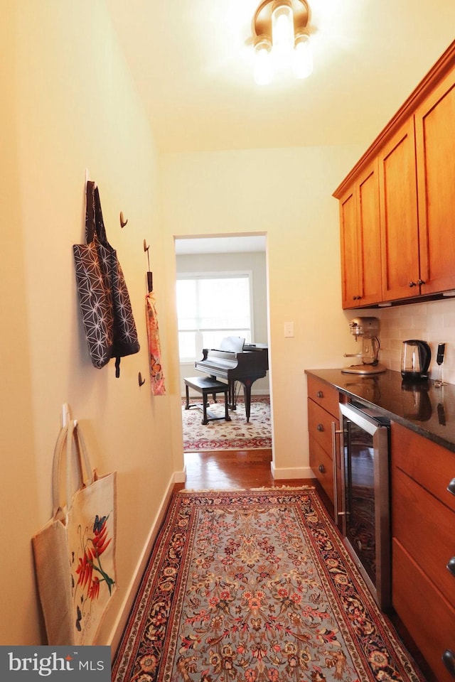 interior space with wine cooler, tasteful backsplash, and baseboards