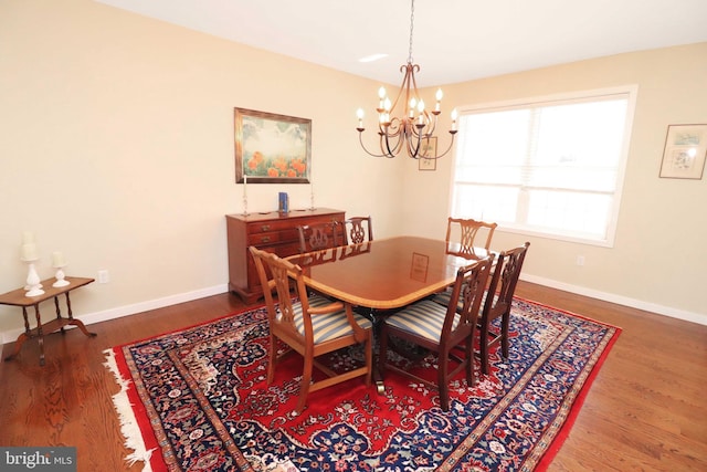 dining room featuring a notable chandelier, wood finished floors, and baseboards