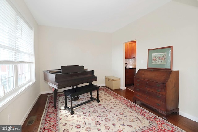 living area featuring visible vents, baseboards, and dark wood finished floors