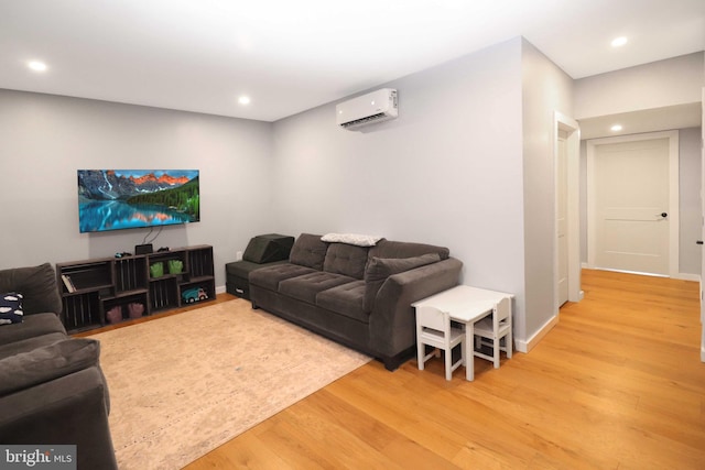 living room featuring recessed lighting, light wood-style floors, baseboards, and a wall mounted air conditioner