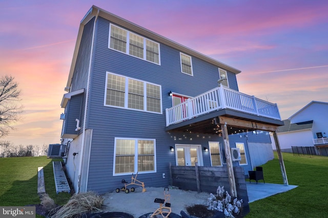 back of property with a deck, a patio area, a yard, and cooling unit