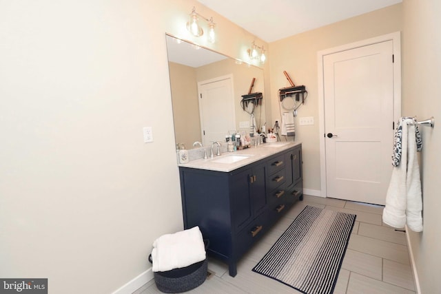 bathroom featuring tile patterned floors, baseboards, and vanity