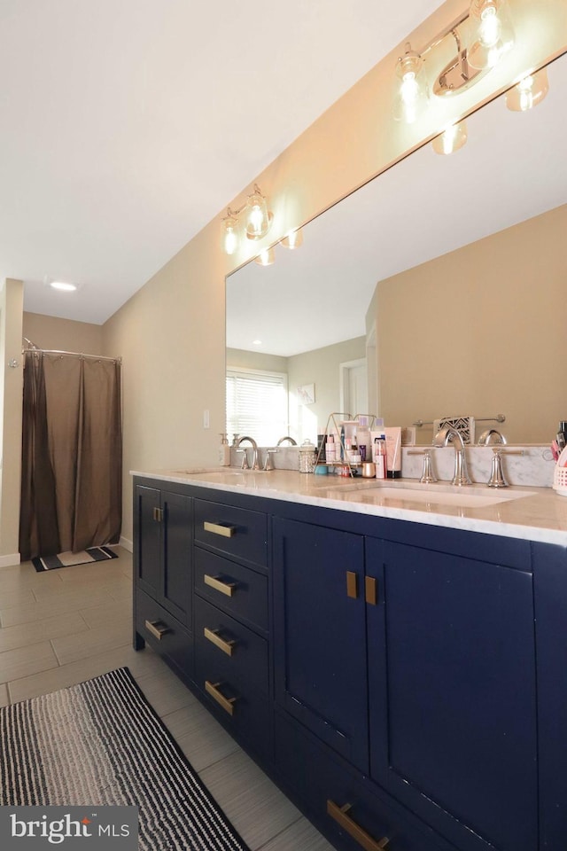 bathroom with a sink, a shower with shower curtain, and double vanity