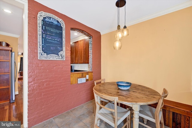 dining room with recessed lighting, brick wall, and crown molding