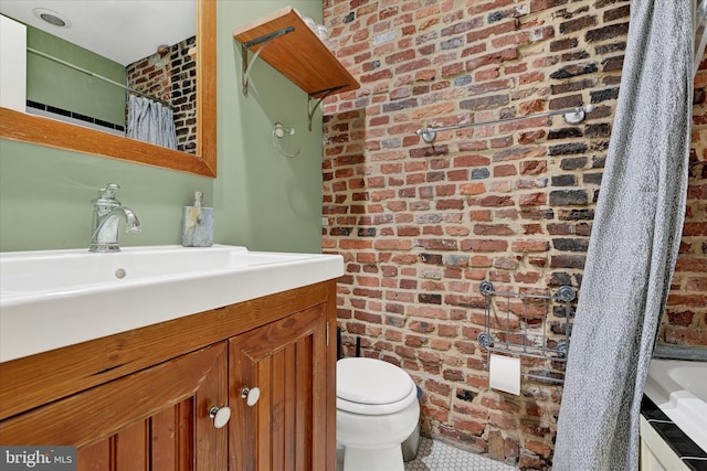 bathroom with a shower with shower curtain, toilet, brick wall, and vanity