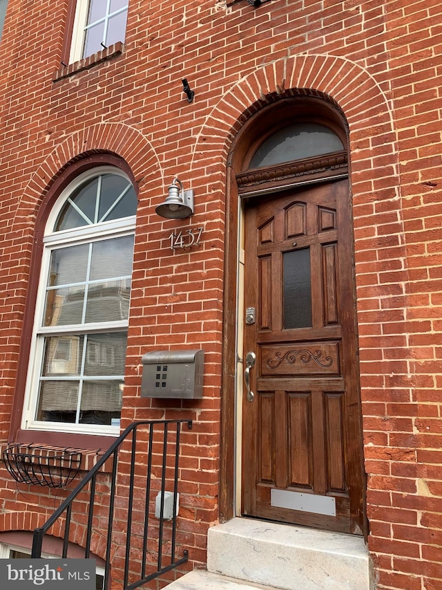 doorway to property featuring brick siding