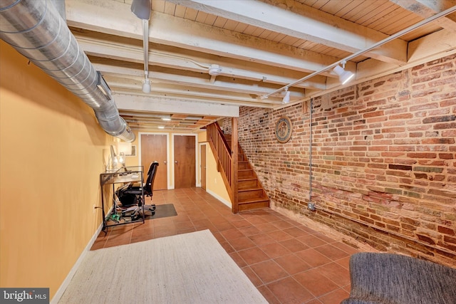 exercise area featuring tile patterned flooring, brick wall, wood ceiling, and baseboards