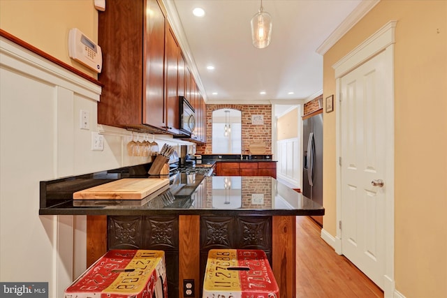 kitchen featuring a peninsula, crown molding, light wood-type flooring, and appliances with stainless steel finishes