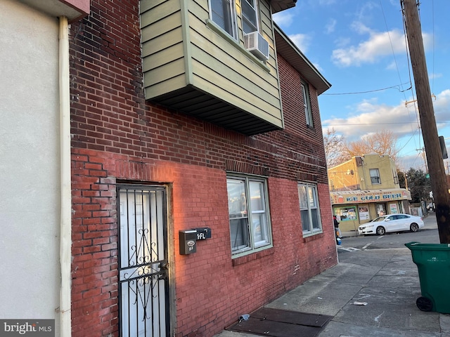 view of side of property featuring cooling unit and brick siding