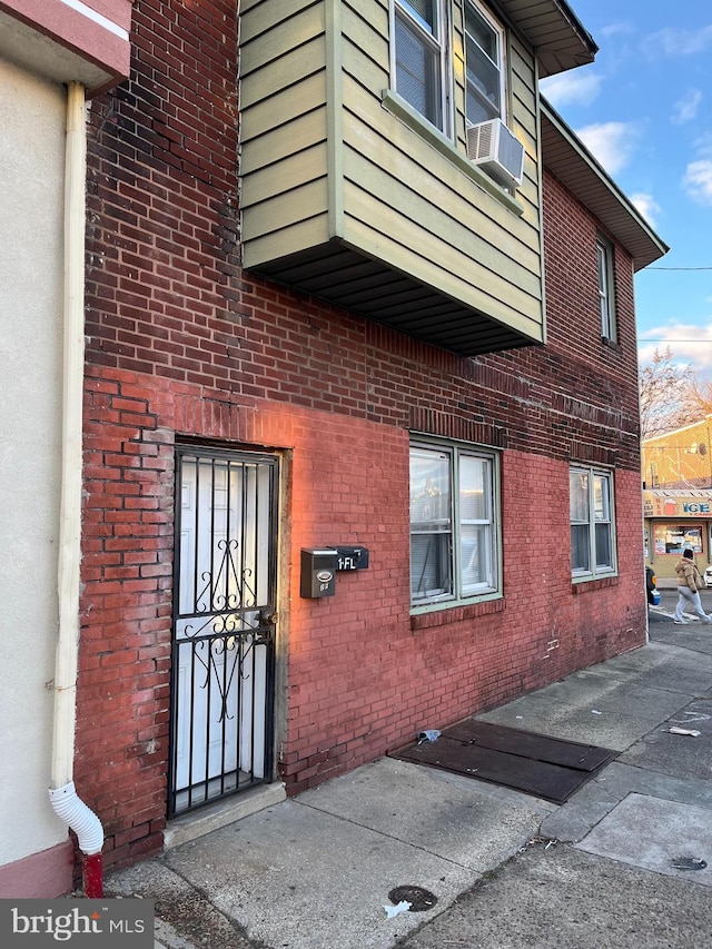 property entrance featuring brick siding and cooling unit