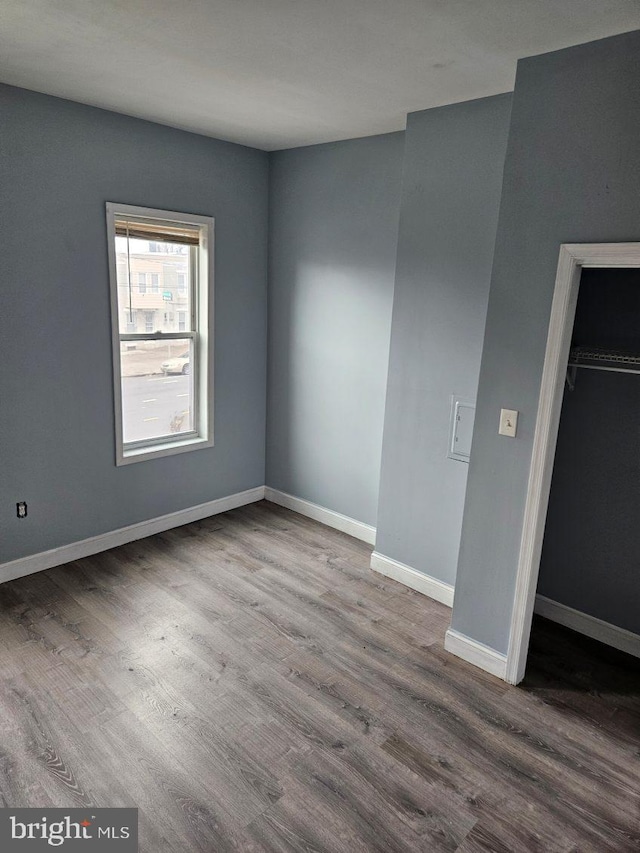 unfurnished bedroom with wood finished floors and baseboards