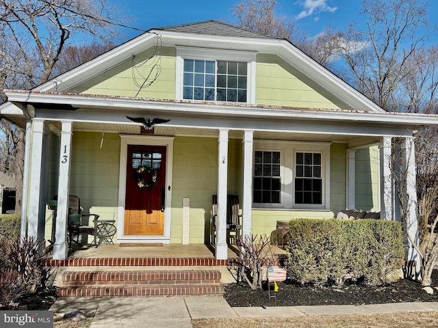 view of front of home with a porch and a shingled roof