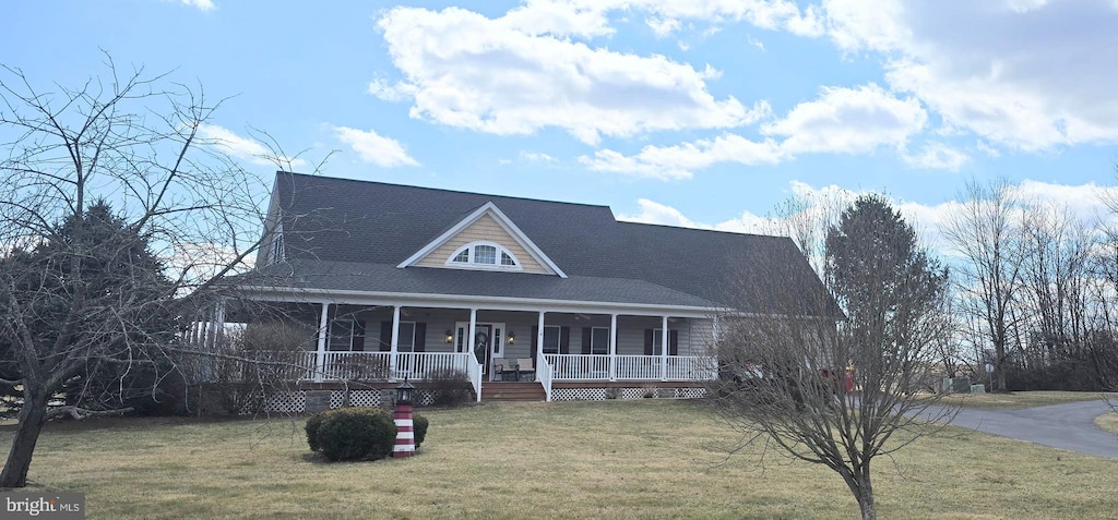 farmhouse-style home with covered porch and a front lawn