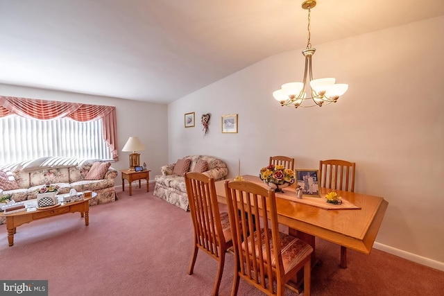 carpeted dining space featuring baseboards, a notable chandelier, and vaulted ceiling