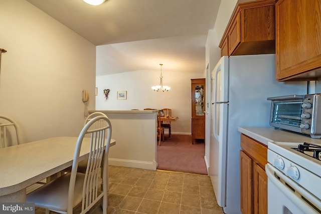 kitchen with brown cabinets, a toaster, vaulted ceiling, light countertops, and white gas range