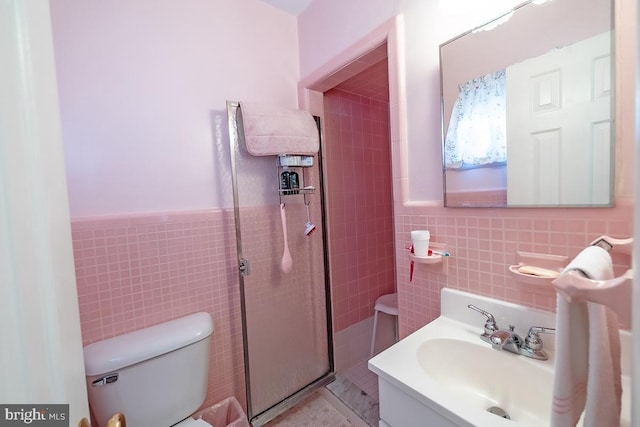 bathroom featuring tile walls, toilet, a tile shower, and wainscoting