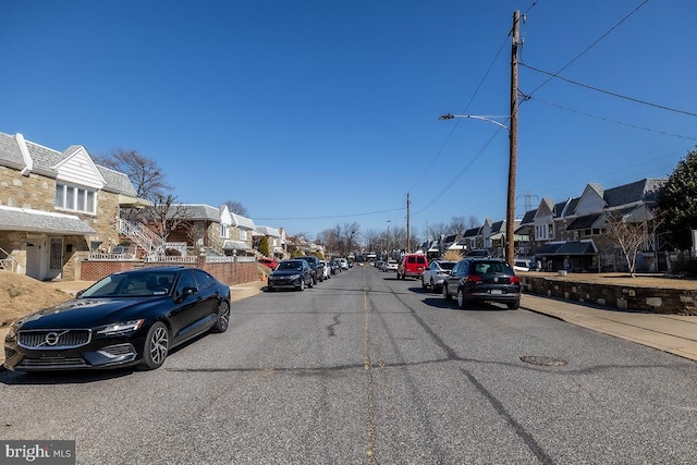 view of street featuring street lights, sidewalks, and a residential view