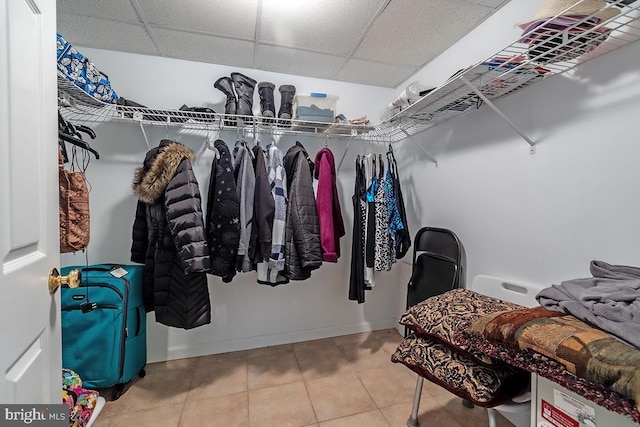 walk in closet with tile patterned floors and a drop ceiling