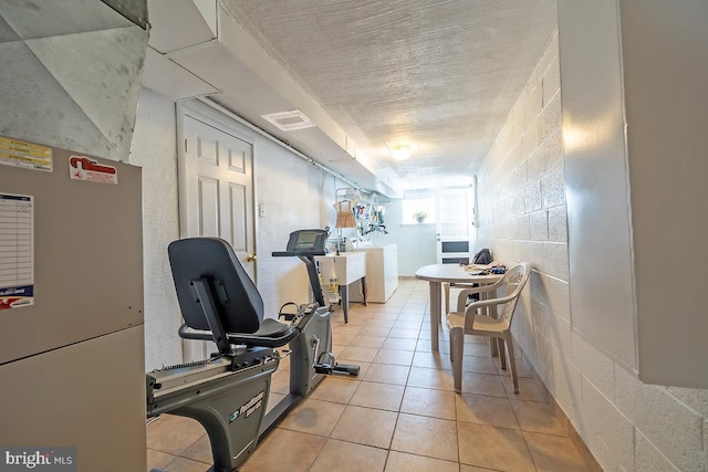 workout area featuring a sink, visible vents, washer / dryer, and light tile patterned flooring