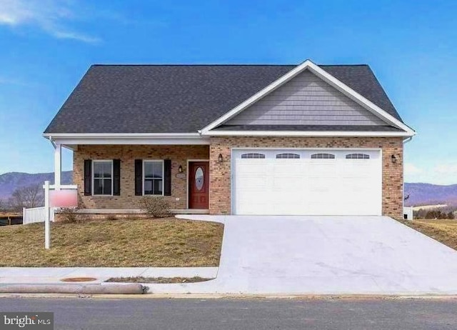 view of front of property with brick siding, a mountain view, driveway, and a garage