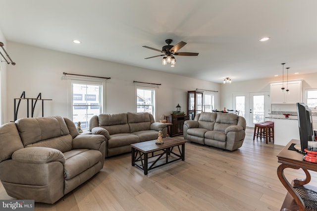 living area with recessed lighting, french doors, and light wood finished floors