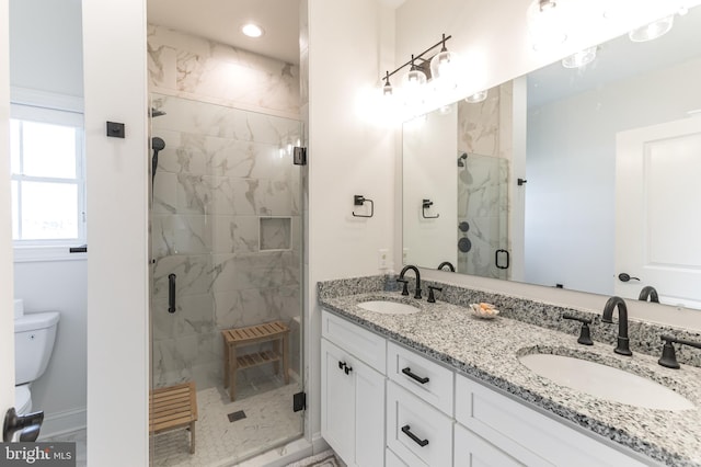 full bath featuring a sink, toilet, double vanity, and a shower stall