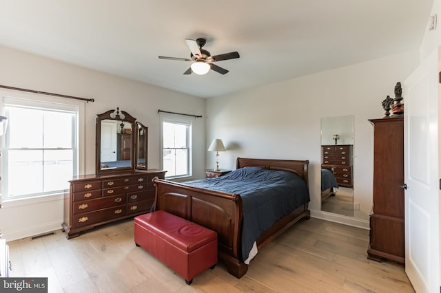 bedroom with visible vents, baseboards, ceiling fan, and light wood finished floors