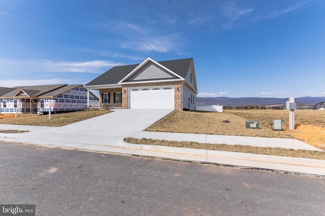 view of front of property featuring a garage, brick siding, concrete driveway, and a mountain view