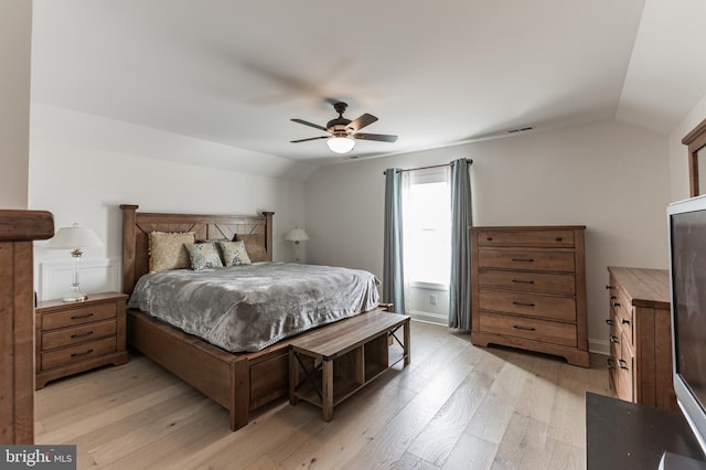 bedroom with vaulted ceiling, light wood-style flooring, a ceiling fan, and visible vents