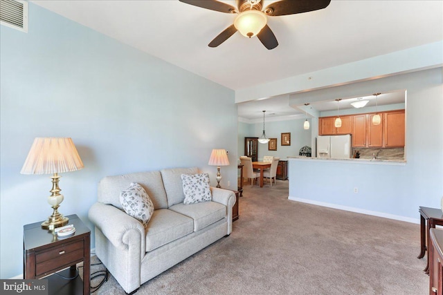 living area featuring light carpet, visible vents, ceiling fan, and baseboards