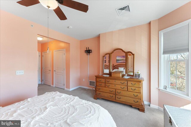 carpeted bedroom featuring visible vents, ceiling fan, and baseboards