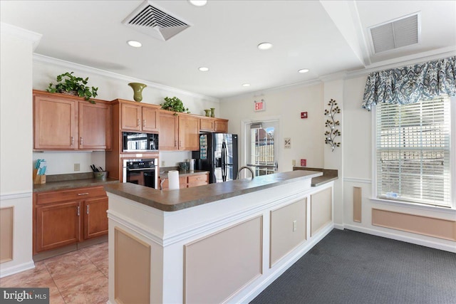 kitchen featuring visible vents, dark countertops, black appliances, and crown molding