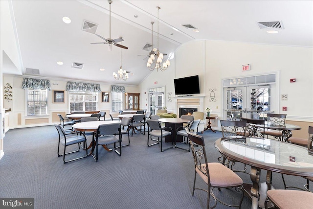 carpeted dining space featuring a wealth of natural light, visible vents, and a lit fireplace