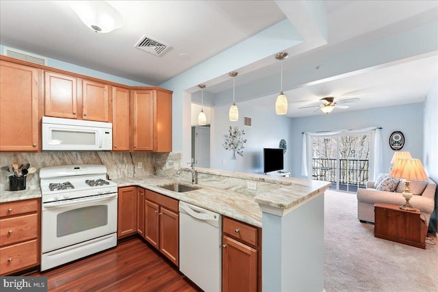 kitchen featuring white appliances, visible vents, a peninsula, a sink, and open floor plan