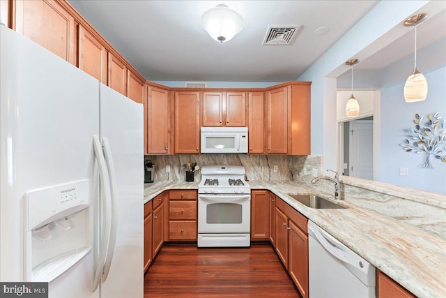 kitchen with visible vents, backsplash, white appliances, and a sink