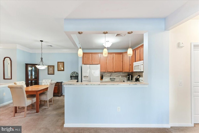 kitchen featuring white appliances, hanging light fixtures, light countertops, light colored carpet, and tasteful backsplash