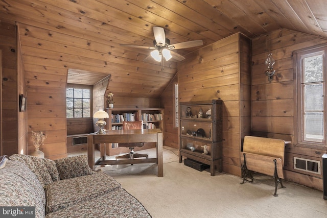 office with vaulted ceiling, wood walls, visible vents, and carpet