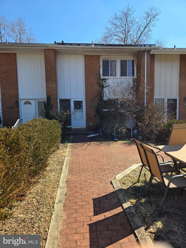 exterior space featuring brick siding and board and batten siding