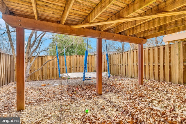 view of yard featuring a trampoline and a fenced backyard