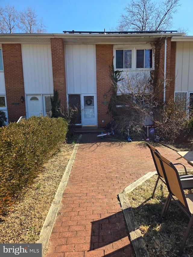 view of front of home with brick siding and board and batten siding