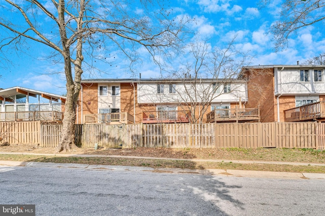 view of property with fence and brick siding