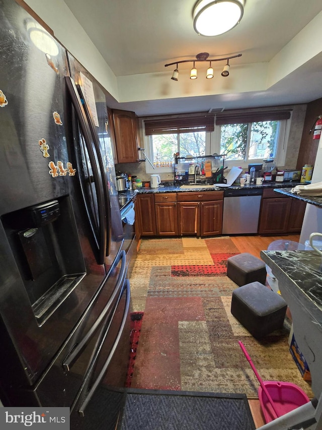 kitchen with brown cabinetry, a healthy amount of sunlight, appliances with stainless steel finishes, and a sink