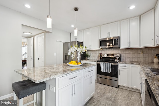 kitchen with stainless steel appliances, tasteful backsplash, and white cabinets