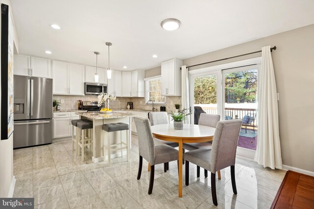 dining space featuring recessed lighting, marble finish floor, and baseboards