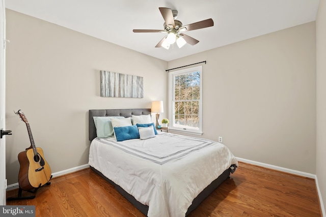 bedroom with baseboards, wood finished floors, and a ceiling fan