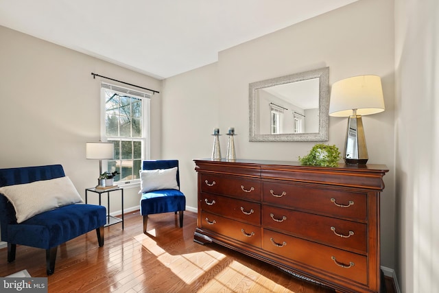 sitting room with baseboards and wood finished floors