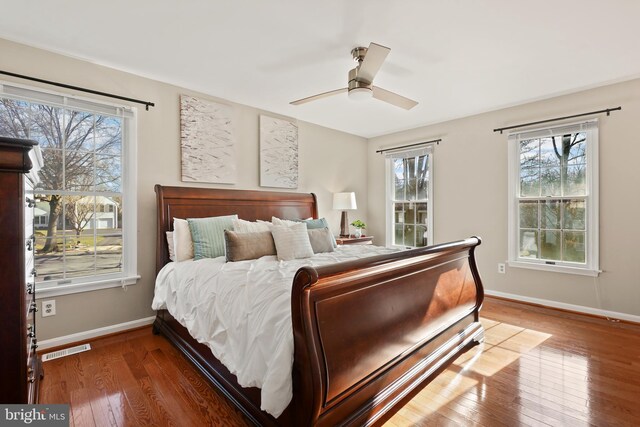 bedroom with visible vents, baseboards, wood-type flooring, and ceiling fan