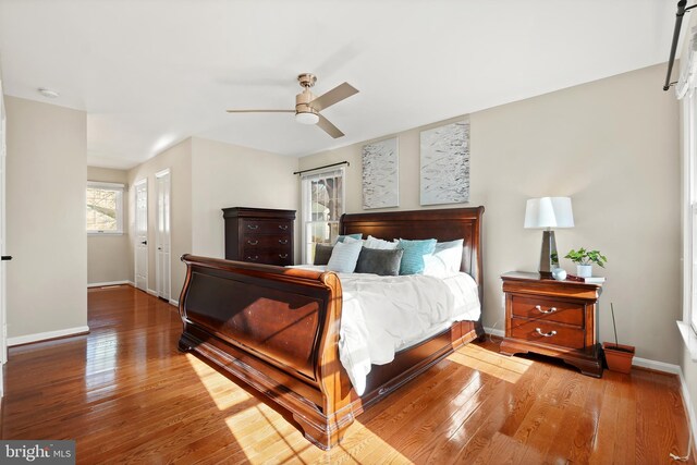 bedroom with a ceiling fan, baseboards, and hardwood / wood-style flooring