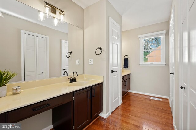 bathroom with visible vents, baseboards, wood finished floors, and vanity